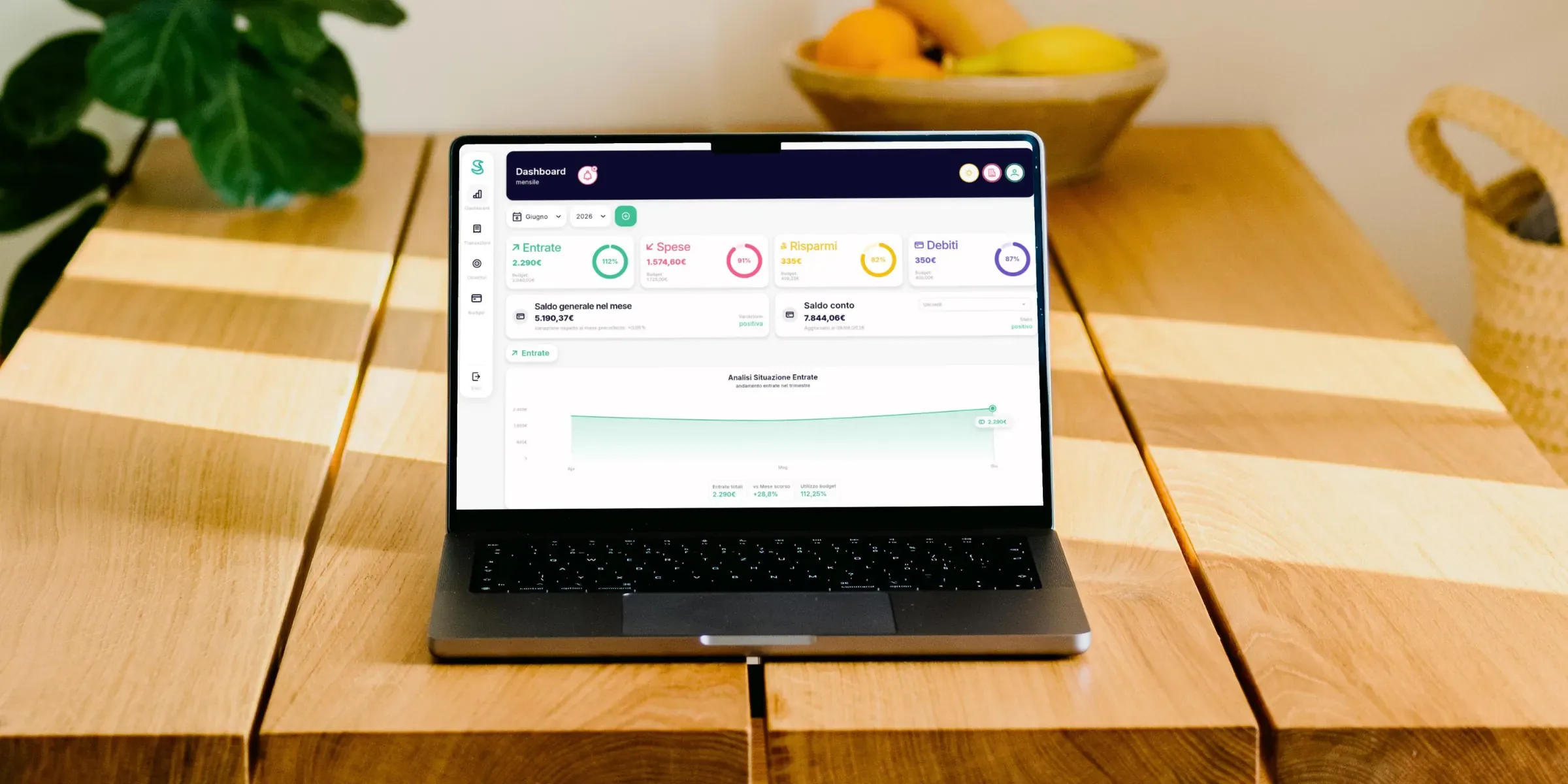App Simple Budget su un MacBook appoggiato sul tavolo della cucina: la dashboard mensile di casa con entrate, spese, risparmi e debiti